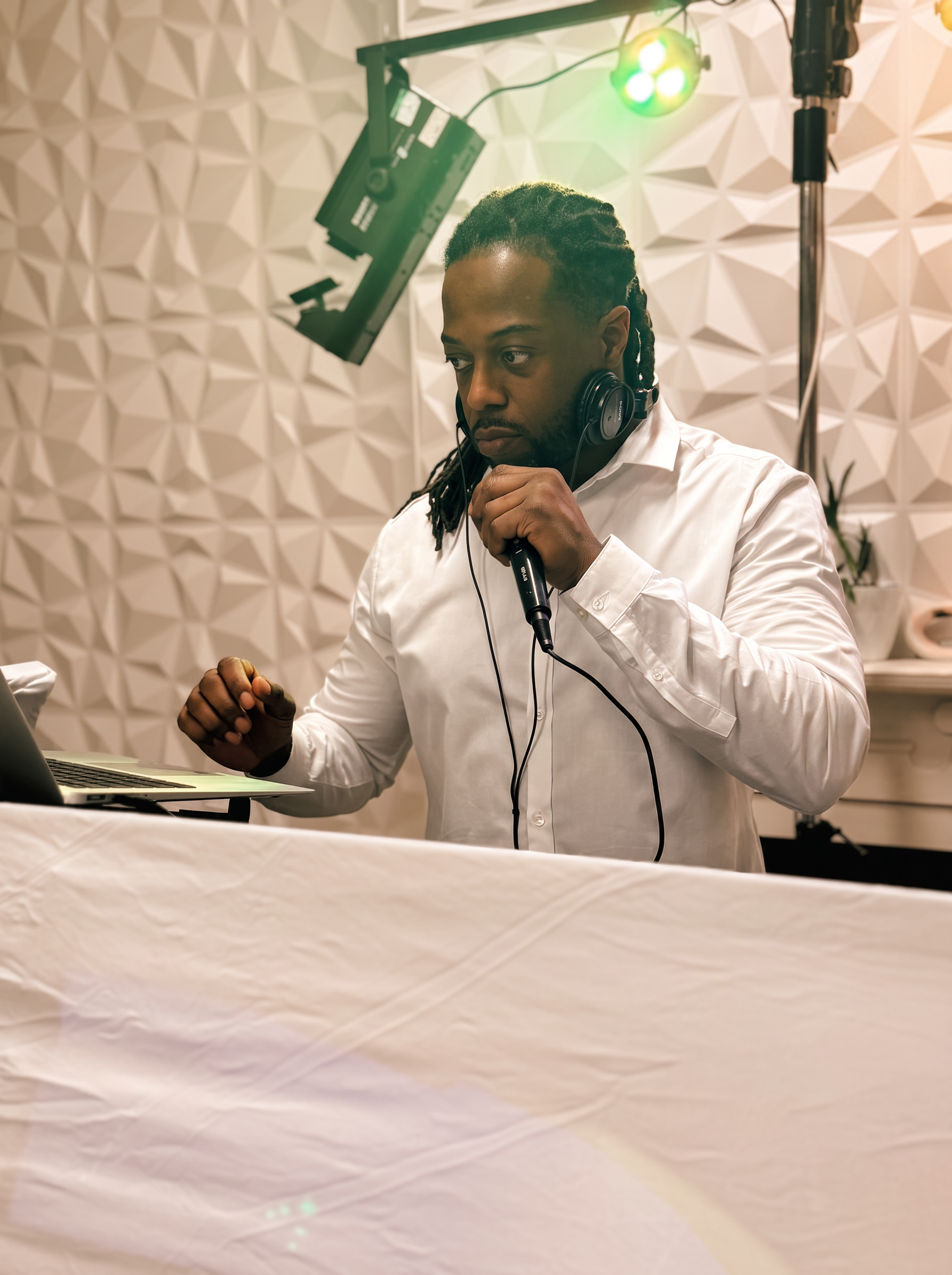 DJ Coda on the microphone in a white shirt at a wedding